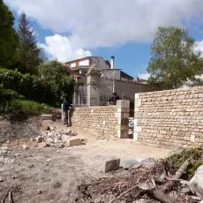 Des ouvriers en cours de réalisation d'un mur en moellons