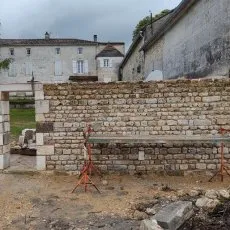 Mur en moellons avec ouverture pour porte en cours de montage